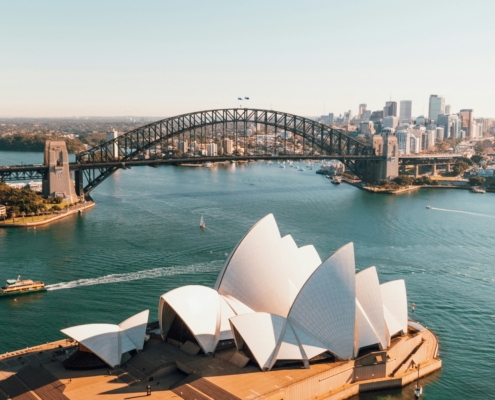 Aerial view of Sydney Opera House with the Sydney Harbour Bridge and city skyline in the distance.