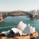 Aerial view of Sydney Opera House with the Sydney Harbour Bridge and city skyline in the distance.