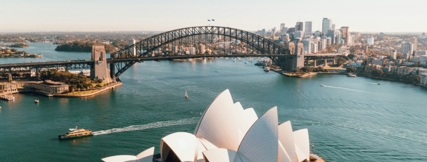 Aerial view of Sydney Opera House with the Sydney Harbour Bridge and city skyline in the distance.